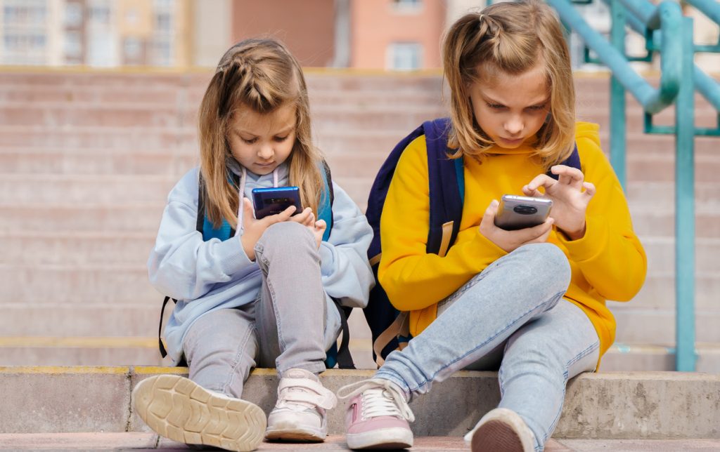 dzieci w szkole korzystają z telefonów