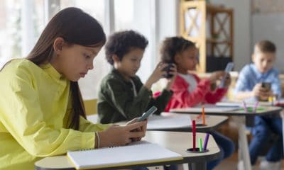 dzieci w szkole korzystają z telefonów