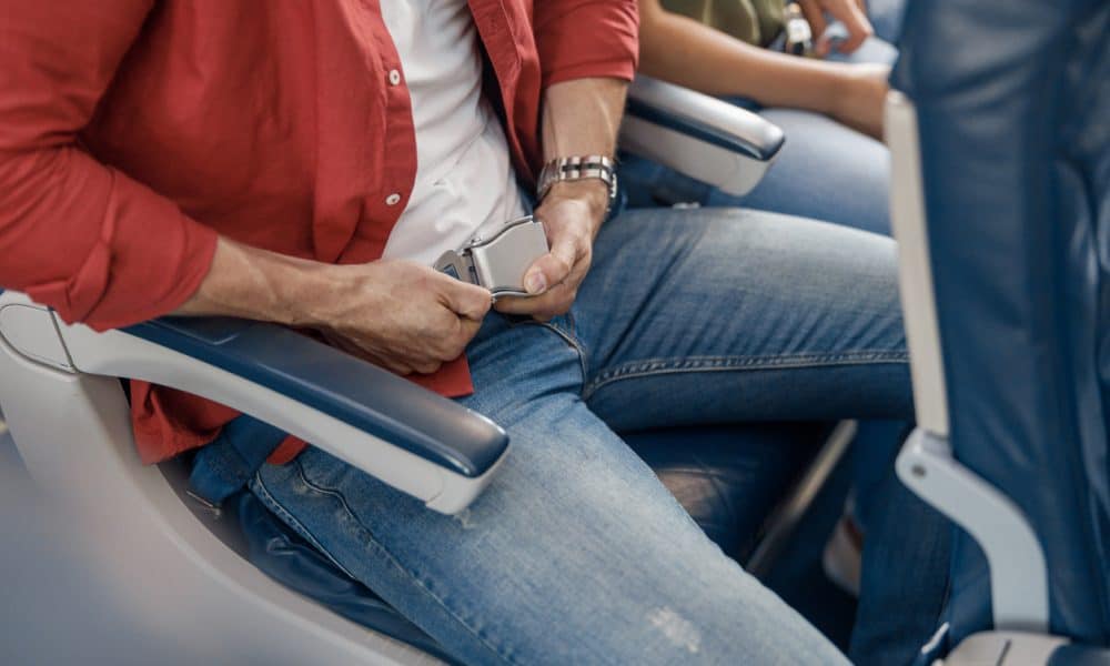 pasażerowie samolotu mają zapięte pasy bezpieczeństwa